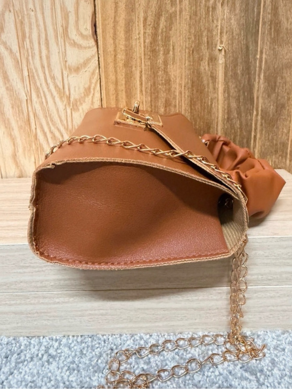 Brown ruched drawstring crossbody bag with gold chain